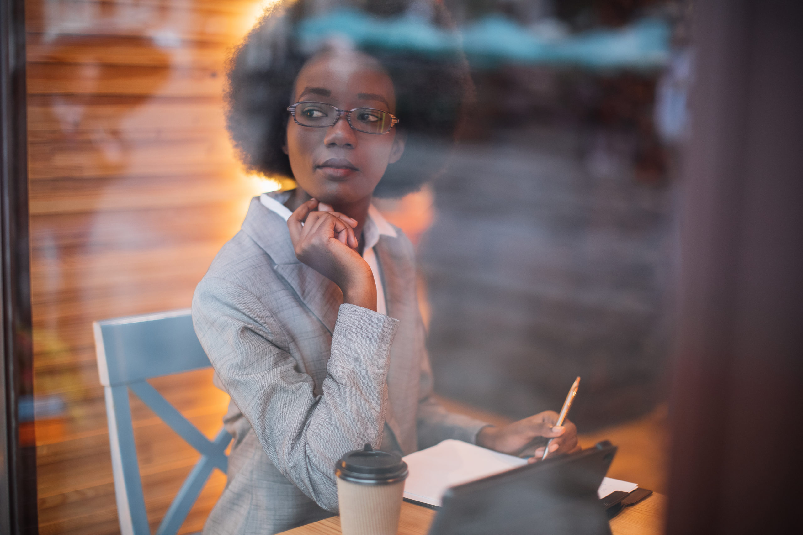 Business woman sitting at cafe with tablet and documents